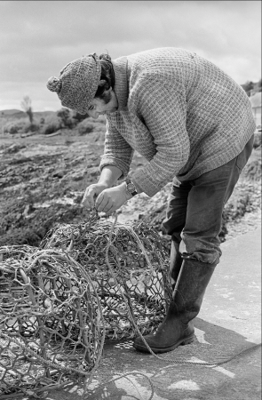 Image Tim O'Leary mending nets on the pier, Whiddy 1981 IMAGE Kevin O'Farrell